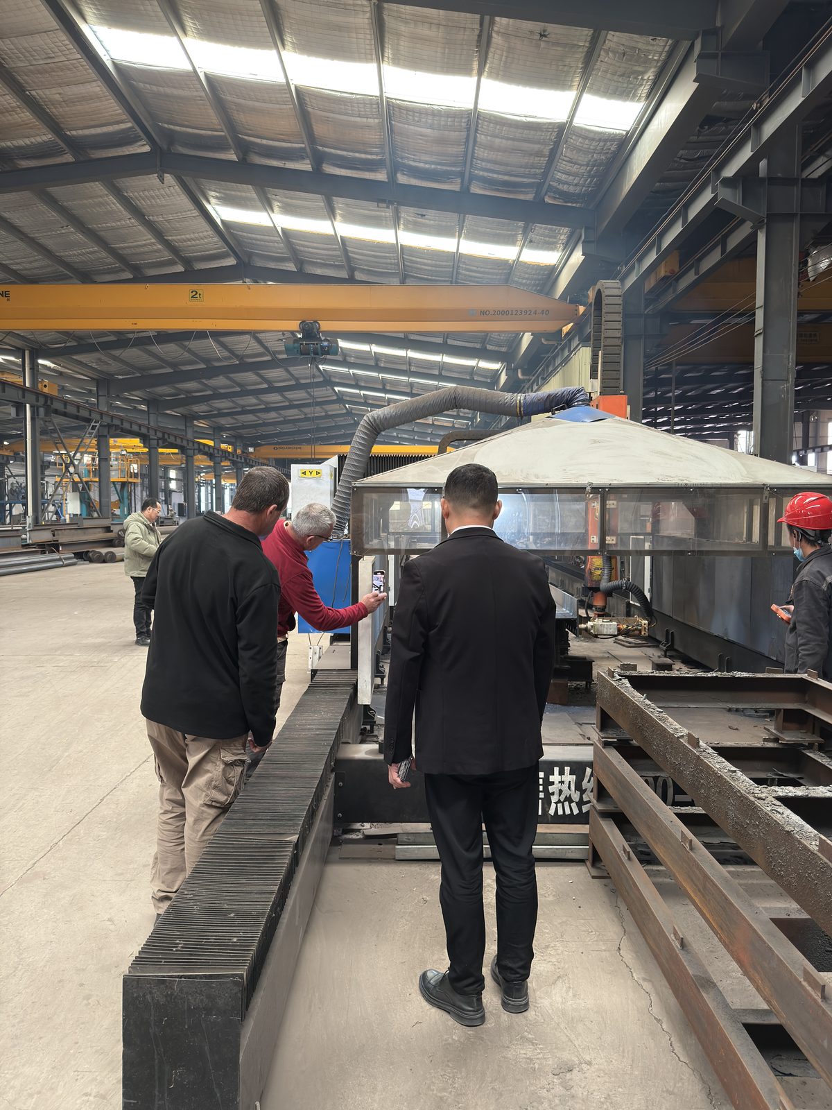Visiting buyers walking the production aisle between crane runways