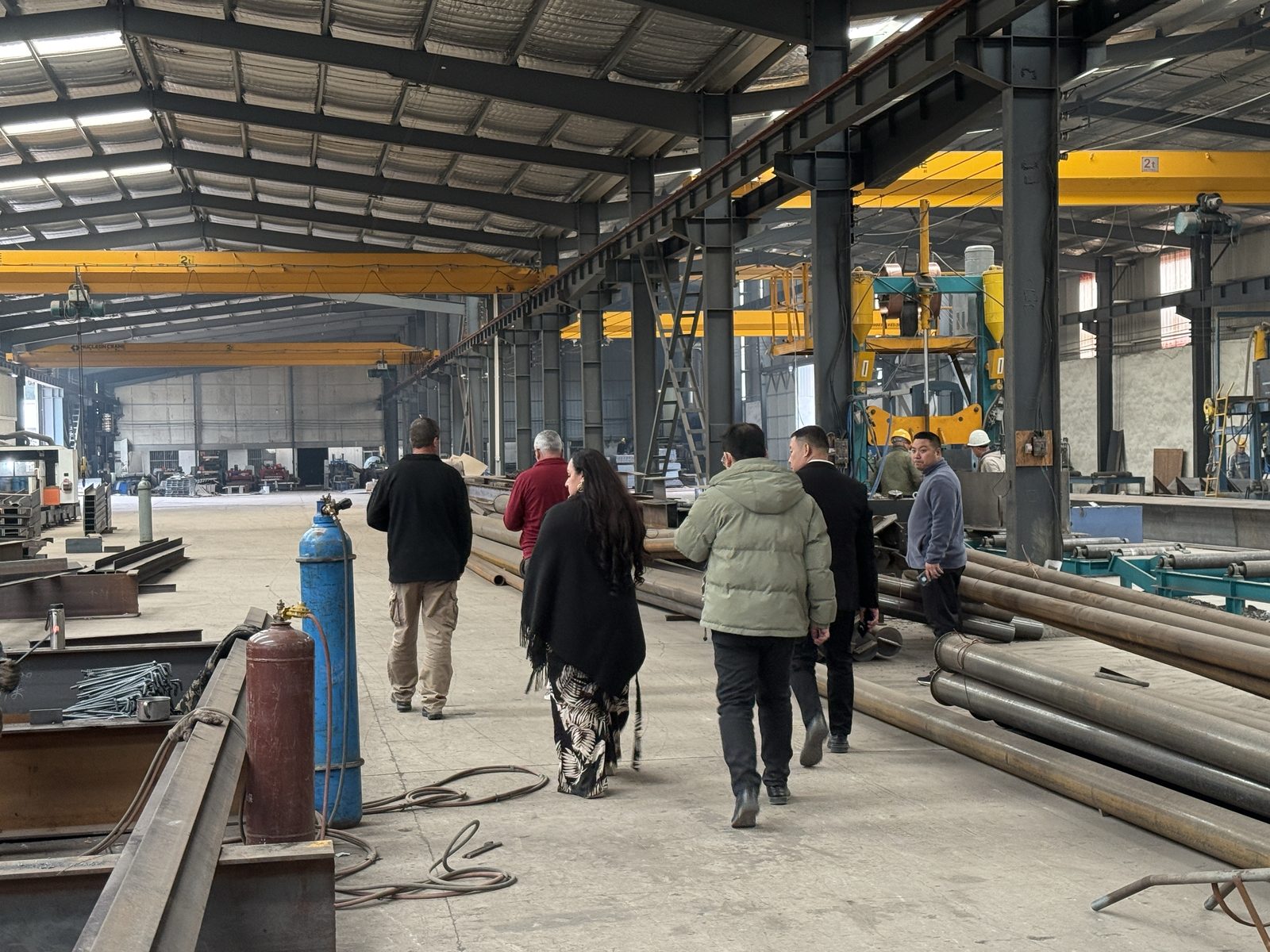 Visitors walking through a fabrication bay past crane rails